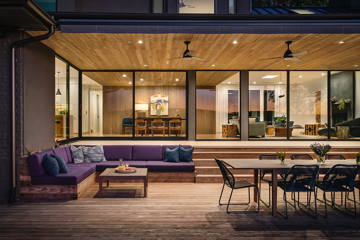 An outdoor dining and lounge area in front of closed multi-slide doors